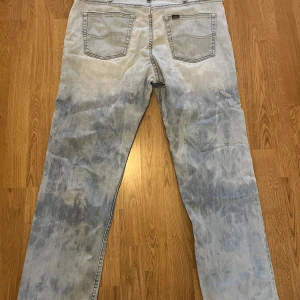 Ljusblå jeans från Lee - Snygga ljusblå jeans från Lee med en klassisk femficksdesign. Jeansen har en avslappnad passform och är perfekta för en casual look. De har en diskret Lee-logga på bakfickan och en läderpatch med Lee-märket vid midjan. W 36, l 29. Classic fit