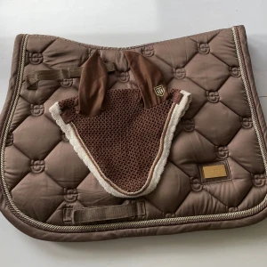 Champagne färgat hoppschabrak från equestrian Stockholm💕 - Otroligt fint hoppschabrak från es i strl full. Huvan är från trinity i strl full också. Säljer schabraket för 400 (nypris 899) och huvan för 100kr ifall man vill köpa huvan separat. 450 kr för båda❤️