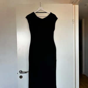 Svart långklänning med öppen rygg - Jättefin och stilren långklänning med öppen rygg och korta ärmar. Sitter väldigt fint på och skönt material!  