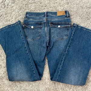 Blå lågmidjade bootcut jeans  - Säljer de trendiga lager 157 jeansen med knapp fickor. Fint skick och inte använda många gånger. Jag är 168cm och de är perfekta i längden💞