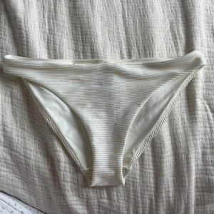 Vit ribbad bikiniunderdel  - Vit bikiniunderdel från H&M i storlek M. Bara använd få tal gånger.  