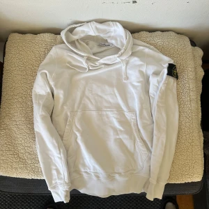 Vit hoodie från Stone Island - Tröjan är väldigt fräsch och ren, ingå fläckar eller hål, ärmslut är inte slitna och hår ingå hål eller fläckar. Skick skulle jag säga är ny. Vid mer frågor eller funderingar det är bara att skriva. Äkthet bevisar koden som finns på lappar. Kan också tänka mig att byta mot en annan stone island eller cp company. OBS skickas ej! Bara avhämtning i Göteborgsområdet.