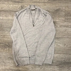 Merinoulls halfzip från Stenströms - Säljer en stilren grå tröja i 100% merinoull från Stenströms. Tröjan har en dragkedja vid halsen och ribbade muddar vid ärmslut och nederkant. Perfekt för kyligare dagar. | 100% Merinoull | Skick: 8/10 | Storleken står inte i men den passar M-L |