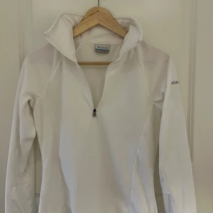 Vit fleece-tröja med halv dragkedja från Columbia - Säljer en vit fleece-tröja från Columbia med halv dragkedja och hög krage.  I storlek Xs har vanligt vis S sitter superfint på. Kunde ej lämna tillbaka 