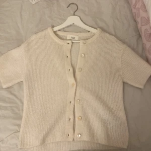 Vit stickad kofta från Gina Tricot - Mysig vit stickad kofta från Gina Tricot i ullblandning. Koftan är supersöt att ha både knäppt och uppknäppt med ett linne under och är oandvänd❤️