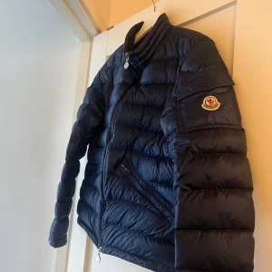 Moncler agay navy  - Säljer den då den har blivit för liten. Storlek 2/M. Kvitto följer med från NK där den är köpt för 8500kr. Hör av er vid ev frågor 