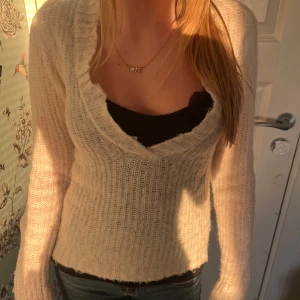Vit stickad tröja från Gina Tricot - Säljer en supermjuk och mysig vit stickad tröja från Gina Tricot. Tröjan har en djup v-ringning och långa ärmar, perfekt att styla med ett linne eller topp under. Enkel att matcha till olika outfits! ( säljer åt kompis)