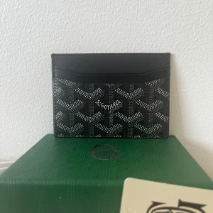 Svart korthållare från Gojard - Snygg svart korthållare från Gojard. Korthållaren har massa fack för kort och lite för sedlar. Perfekt  för dig som vill ha något lyxigt och smidigt. Helt oanvänd och helt ren. Jättebra material och kvalité. PRISET KAN DISKUTERAS.