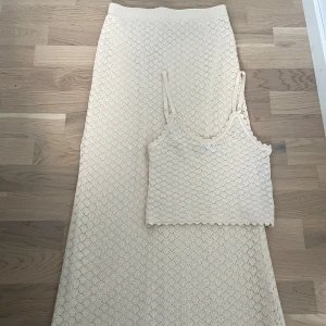 Beige virkat set med långkjol & topp - Säljer ett set med en beige långkjol & topp med vackert virkat mönster. Mycket fint skick, endast använt vid ett tillfälle. Perfekt till midsommar osv