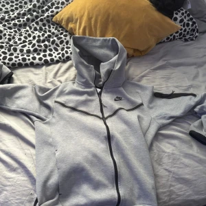 Grå zip-hoodie från Nike - Säljer min gråa Nike Teach perfekt nu till sommaren.
