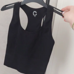 Svart croppad linnetopp från Cubus - Säljer en svart croppad linnetopp från Cubus. Toppen har breda axelband och rundad halsringning, perfekt för sommaren eller som lager på lager. Enkel och stilren design som passar till mycket.