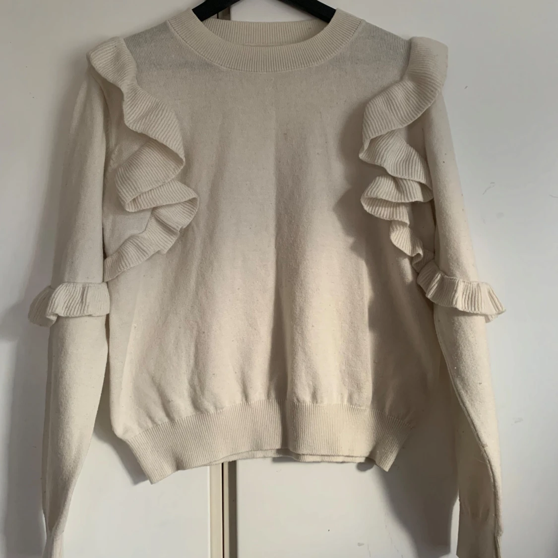 Vit stickad tröja med volangdetaljerđ