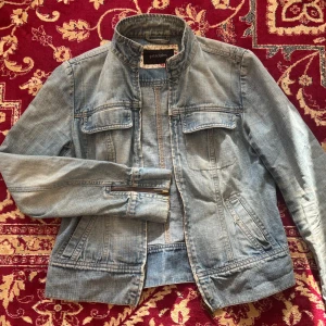 Ljusblå jeansjacka från Principles - Säljer en ljusblå jeansjacka från Principles med ståkrage och dragkedja framtill. Jackan har två bröstfickor med lock och dragkedjor vid ärmsluten. Snygg och enkel modell som passar till mycket.