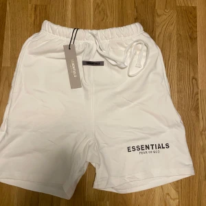 Vita shorts från Essentials Fear of God - Snygga vita shorts från Essentials Fear of God med elastisk midja och snörning. Klassisk design med logga framtill. Perfekta för en clean och stilren look.