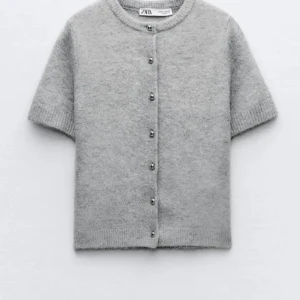 Grå kortärmad kofta från Zara - Grå kofta från Zara. Använt fåtal gånger så inga defekter! Den är aningens croppad så den passar mig som bär oftast M💕