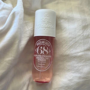 Brazilian Crush Cheirosa 68 Perfume Mist - En fräsch och tropisk body mist från Sol de Janeiro med doftnoter av rosa drakfrukt, brasiliansk jasmin och solkysst vanilj. Flaskan är rosa med vit kork och har en sprayfunktion för enkel applicering. Ca 50/45% kvar av tot 240ml, se bild 3.