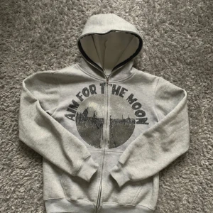 Aim For The Moon Rhinestone Hoodie - Säljer denna grå Aim for the Moon hoodie. Den har en dragkedja och är perfekt för både höst och vår. Alla stenar är inte kvar. Superbekväm och stilren. Hoodien är rare, och slutsåld så det går inte att få den ny.