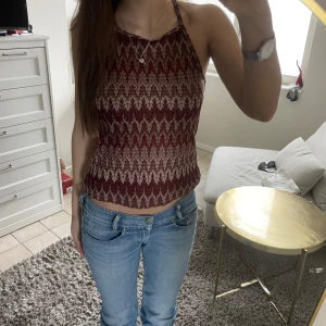 Röd mönstrad halterneck linnetopp - Säljer en snygg röd och beige halterneck topp med mönster. Perfekt till sommaren och passar till både jeans och kjol. Från missoni 