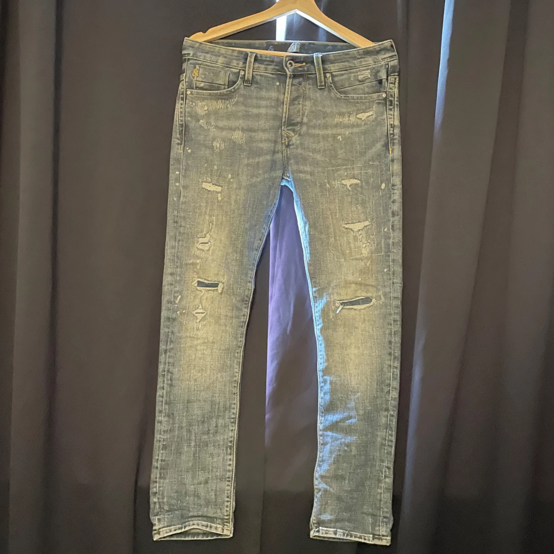 Blå slitna jeansbyxor