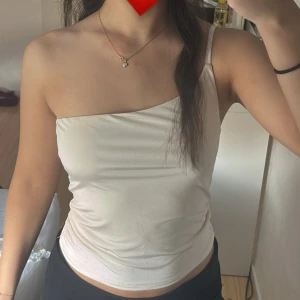 Vit oneshoulder topp - Snygg vit oneshoulder topp med smal axelrem. Toppen är i lite åt silke hållet❤️XS/S