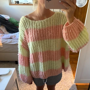 Randig stickad tröja - Supermysig stickad tröja med breda pastellfärgade ränder i ljusrosa och ljusgrön. Tröjan har oversized passform, lång ärm och grovstickad struktur💚💛🩷