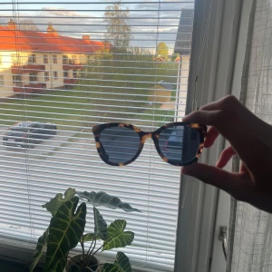 Leopardmönstrade solglasögon från Moncler - Snygga solglasögon från Moncler med leopardmönstrad båge och mörka glas. Klassisk fyrkantig form som ger en cool look. Kommer med svart fodral och putsduk från moncler. Köpta för 2000kr