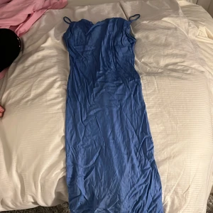 Blå långklänning från Kappahl - Säljer en blå långklänning från Kappahl med smala axelband. Klänningen har en enkel och stilren design, perfekt för sommarens alla tillfällen. Materialet känns mjukt och följsamt mot kroppen.Kom gärna med prisförslag och skriv för fler bilder