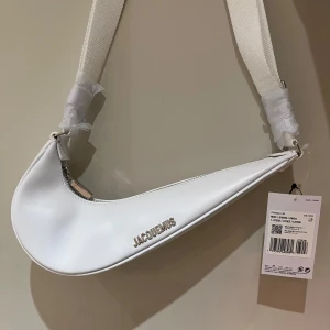 Nike Jacquemus Le Swoosh bag white - Säljer en supertrendig vit axelväska från Jacquemus x Nike med unik böjd form och bred axelrem. // comes without the dust bag // new and unworn 