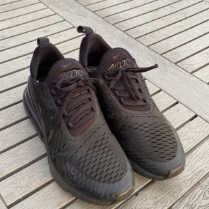 Svarta Nike Air Max 270 sneakers - Säljer ett par helsvarta Nike Air Max 270 sneakers med synlig luftbubbla i sulan. Skorna har mesh-överdel för bra ventilation och snörning framtill. Perfekta för både streetstyle och träning. Priset kan diskuteras.
