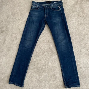 Mörkblå jeansbyxor från Replay - Säljer ett par mörkblå jeans från Replay med klassisk femficksdesign och raka ben. Perfekta för dig som gillar en tidlös och stilren look.