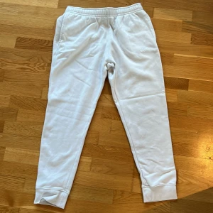 Vita Nike mjukisbyxor   - Säljer ett par vita mjukisbyxor från Nike. Byxorna har en enkel och clean design med diskret Nike-logga på ena benet. Perfekta för chill eller träning.