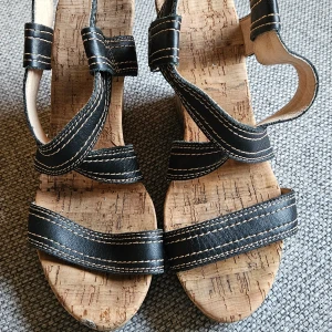Sandaler med kilklack - Snygga och höga klackar. Remmarna är av skin. Sulan av kork. Jag har haft dom på ett bröllop. Strl 38