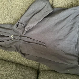 Marinblå hoodie - Säljer en marinblå hoodie med justerbar dragsko i huvan. Den har långa ärmar och en klassisk passform.