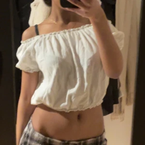 Vit offshoulder blus - Säljer en söt vit offshoulder blus med korta ärmar och elastisk kant. Perfekt för varma dagar och ger en avslappnad look. Passar bra till både jeans och kjol.