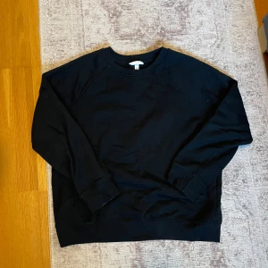 Svart sweatshirt från H&M - Säljer en klassisk svart sweatshirt från H&M. Tröjan har en rund halsringning och långa ärmar med ribbade muddar. Perfekt för en avslappnad stil. 