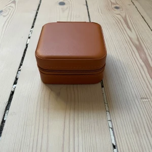 Smyckeskrin - Säljer ett brunt smyckeskrin. Aldrig använt. Nypris: 199kr. Mått, längd: 10 cm, bredd: 10 cm, höjd: 5,2 cm. Skriv vid frågor. 