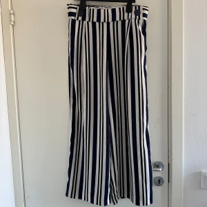 Randiga kostymbyxor från Zara - Snygga randiga byxorbyxor från Zara i blått och vitt. Byxorna har en hög midja med knappar. (Katt och kanin finns i hemmet) 