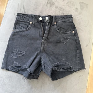 Jeansshorts  - Svarta högmidjade shorts med slitningar. Använda 1 gång.