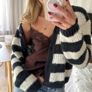 Randig kofta i svart och vit - Säljer en mysig randig kofta i marinblå och vit med knappar framtill! Storlek S