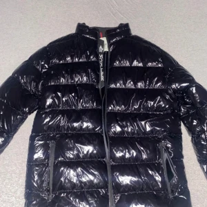 Moncler Jacka - Ej Ä..K..T..A! Jackan passar förmodligen mot L hållet, men förmodligen XL är osäker i det. Väldigt bra pris, för en sådan kvalite. Aldrig använd, samt inga skavanker! 