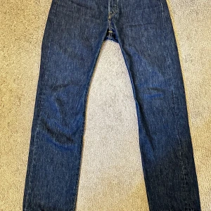 Levis 501 jeans - Klassiska Levis 501 jeans i en snygg mörkblå färg. De har en rak passform och är tillverkade i slitstarkt denim. Perfekta för en tidlös stil.