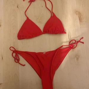 Röd bikini med knytband - Snygg röd bikini med trekantsöverdel och knytband både i nacken och ryggen. Underdelen har knytband på sidorna för justerbar passform. Perfekt för soliga dagar på stranden!💗💗
