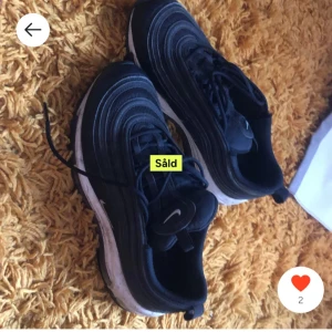 Svarta Nike sneakers - Säljer ett par svarta Nike sneakers med vit sula och snörning. Skorna har en sportig design med vågformade detaljer på ovansidan. Perfekta för en casual look eller träning. Skicket är 8/10 typ de år helt rena inga hål eller märken den är ej såld det står bara så