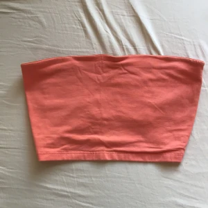 Orange tubtopp från Gina Tricot - Säljer en snygg orange tubtopp från Gina Tricot. Perfekt för sommardagar och enkel att matcha med olika outfits. Toppen är ärmlös och tillverkad i ett mjukt material.