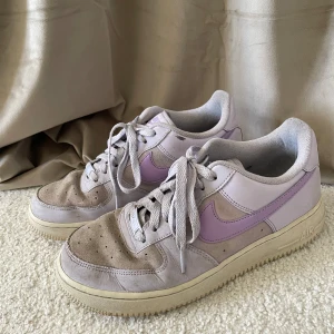 Nike Air Force 1  - Ljuslila Nike AF1 med mockadetaljer samt fakeläder. Hälen i högra skon är något trasig därav lågt pris, annars fina bara lite smutsiga men de är bara att köra i tvättmaskinen! 🩷