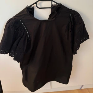 Svart blus med spetsdetaljer - Snygg svart blus med korta ärmar 