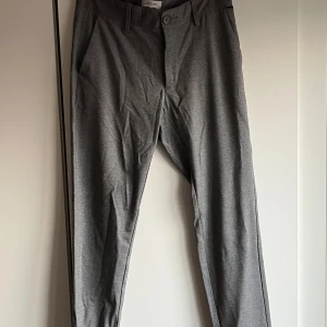 Grå kostymbyxor från Only & Sons - Snygga grå kostymbyxor från Only & Sons med en klassisk design. Byxorna har en normal passform. Perfekta för en stilren look.