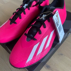 Rosa fotbollsskor från Adidas - Snygga rosa fotbollsskor från Adidas med vita detaljer och svart snörning. 