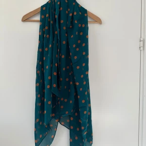 Helt NY Grön sjal med orange prickar - Snygg och färgglad turkos halsduk med orange prickar. Perfekt för att liva upp din outfit med lite färg och mönster. Halsduken är lätt och luftig, vilket gör den idealisk för vår och sommar. Ett måste för den stilmedvetna! Ny i förpackning