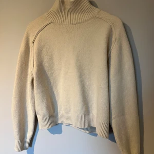 Beige stickad polotröja från H&M - Säljer en stilren beige stickad polotröja från H&M. Tröjan har en hög polokrage och långa ärmar med ribbade muddar. Storlek M, normal i storleken. Aldrig använd. 150kr eller bud.